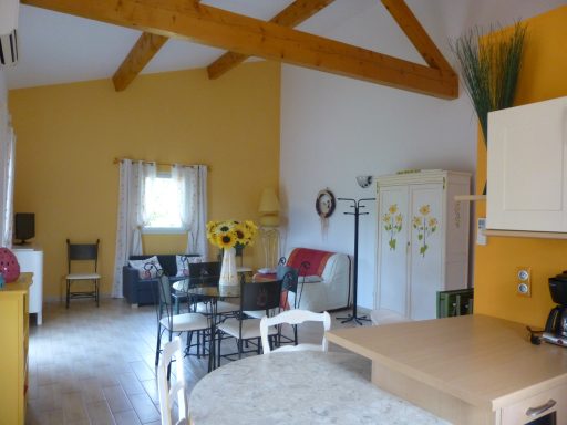 Intérieur d'une pièce lumineuse avec des murs jaunes et des meubles variés.